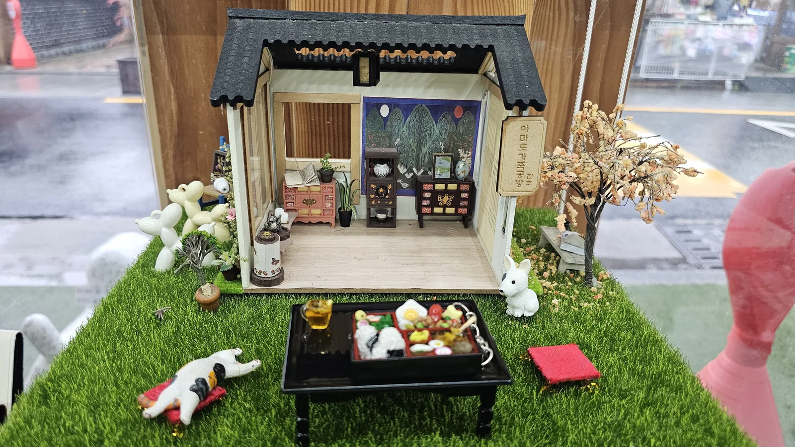 Amado Leather Workshop hanok miniature diorama display with completed lunchbox keyring placed on a small traditional tray