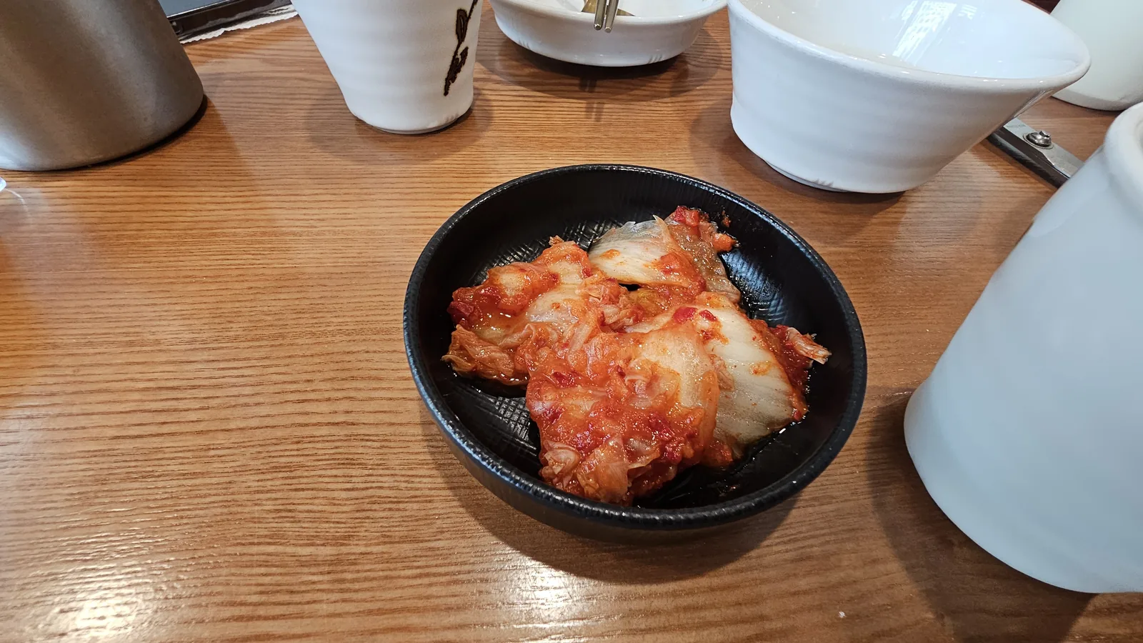 ボンチュチムダク汝矣島店の黒い器に盛られたキムチのおかず