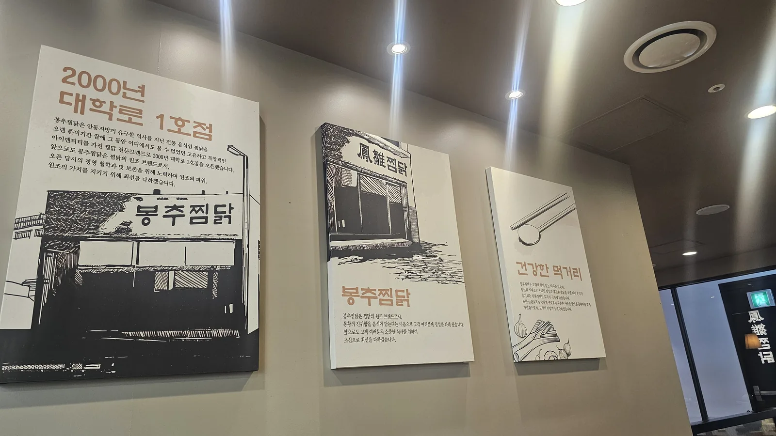 ボンチュチムダク汝矣島店に掲示されたブランド沿革パネル(2000年大学路1号店の起源)