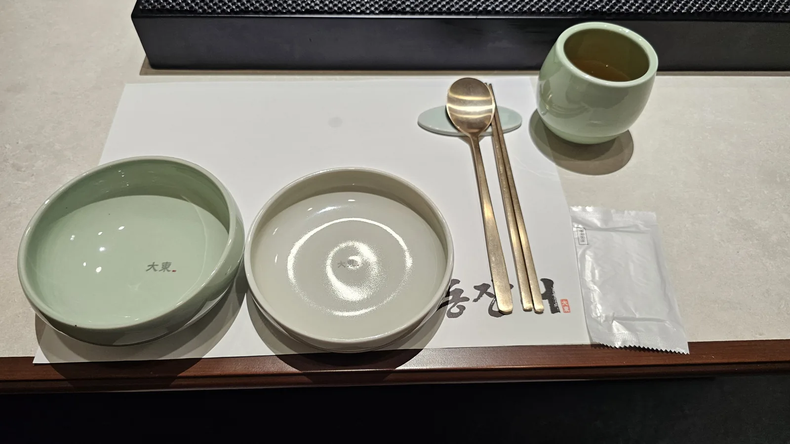 Daedong Jangeo branded celadon bowl and plate with brass chopsticks and spoon table setting