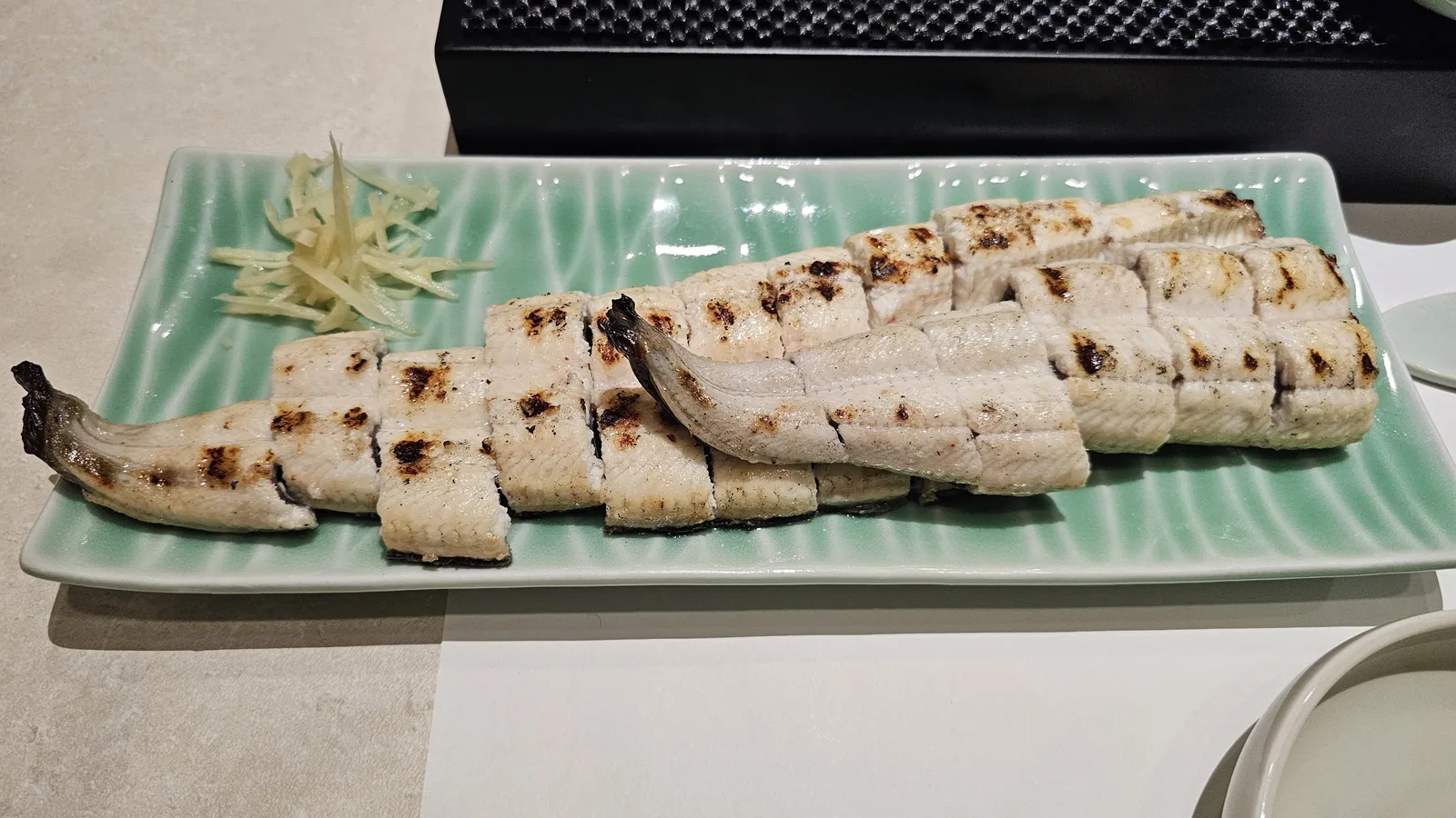 Salt-grilled freshwater eel on celadon rectangular plate with pickled ginger at Daedong Jangeo Yeouido