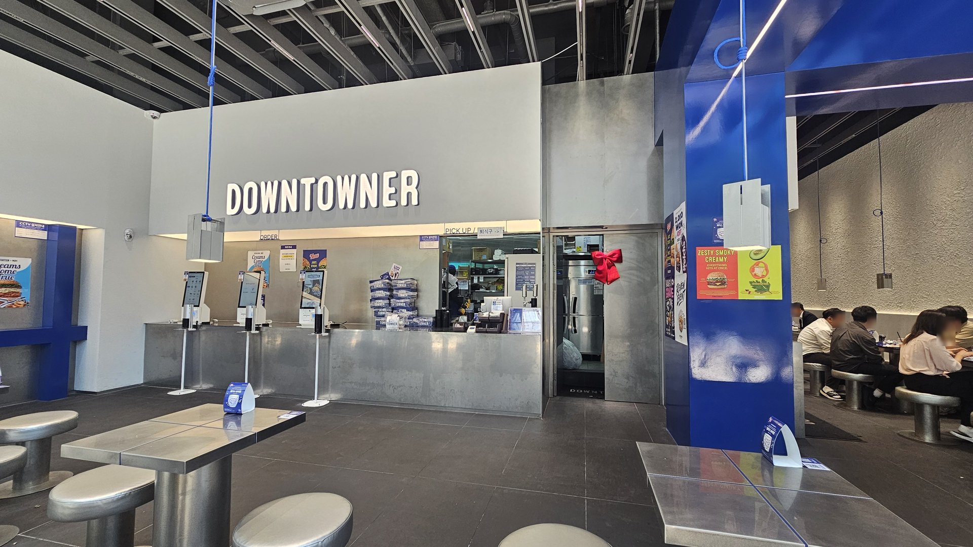Downtowner Yeouido interior counter and pickup area with DOWNTOWNER sign and customers seated to the right