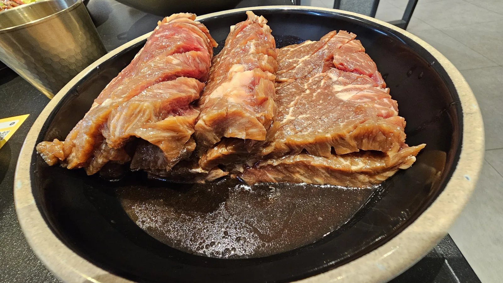 Raw King beef short ribs in ceramic dish before grilling at Galbidorak Guro