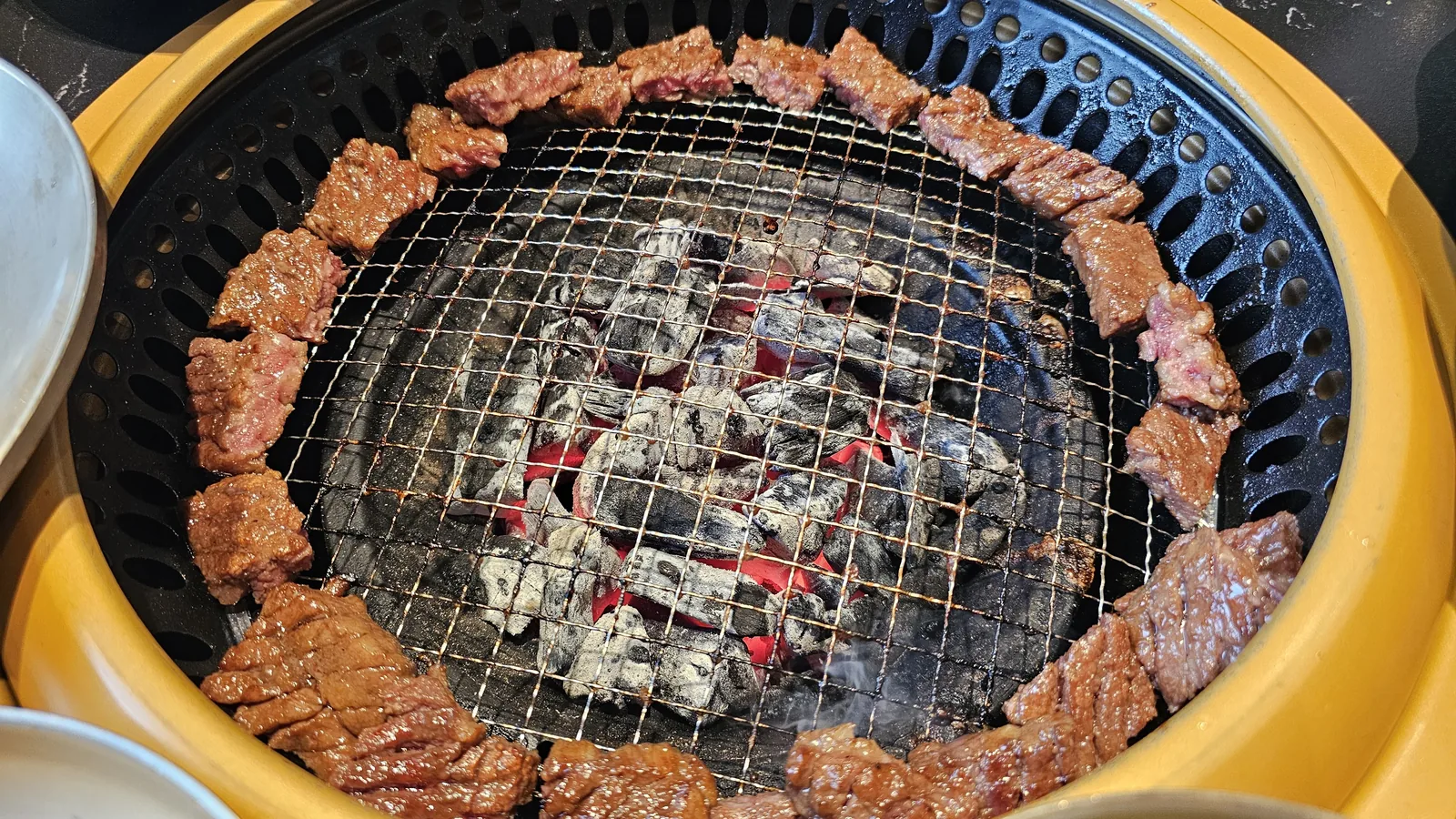 Marinated beef pieces on charcoal grill edge at Galbidorak from a different angle