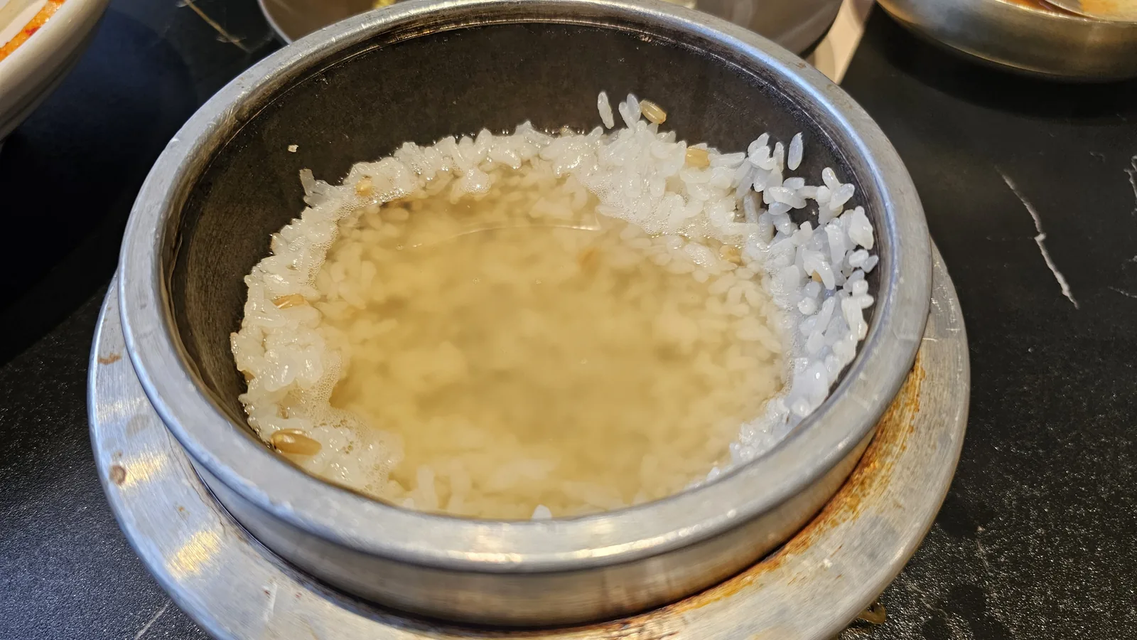 Nurungji scorched rice water in stainless pot, traditional end-of-meal drink at Galbidorak