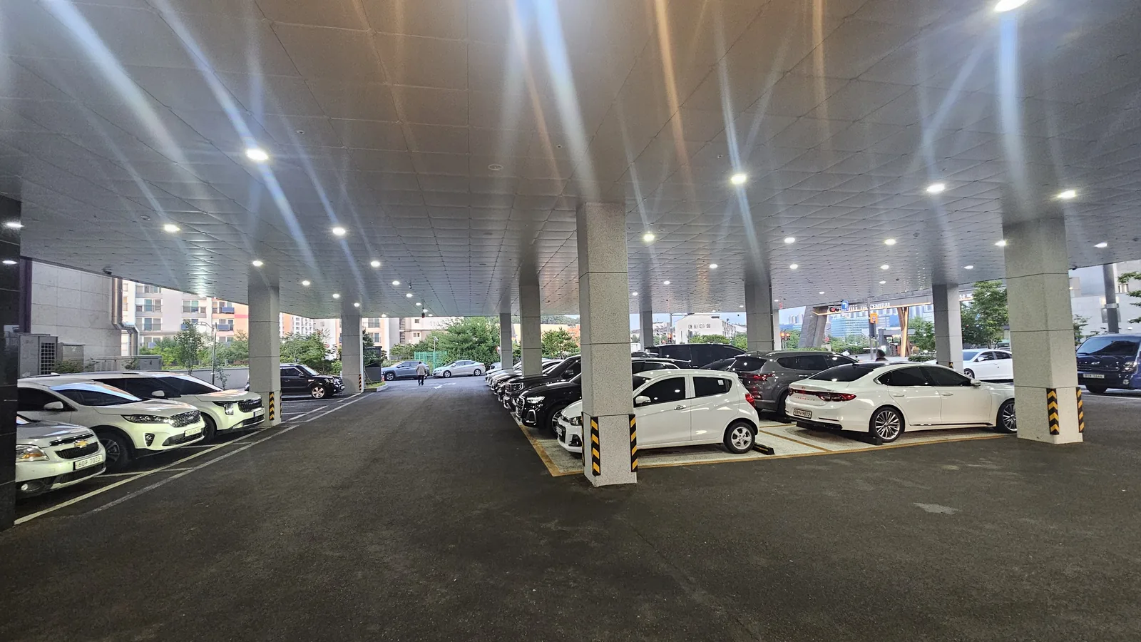 Galbidorak Guro large covered parking lot with cars parked during evening hours