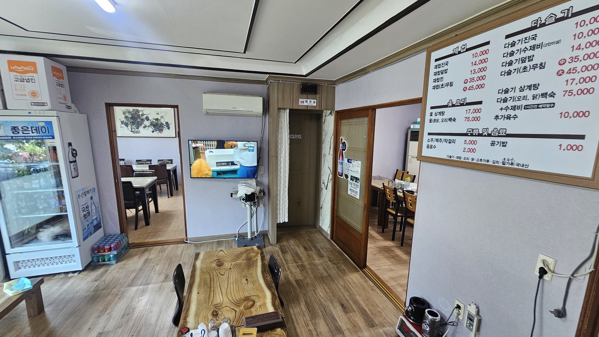 Interior entrance area of Gareung Sikdang with drink refrigerator, TV, and hallway to private dining rooms