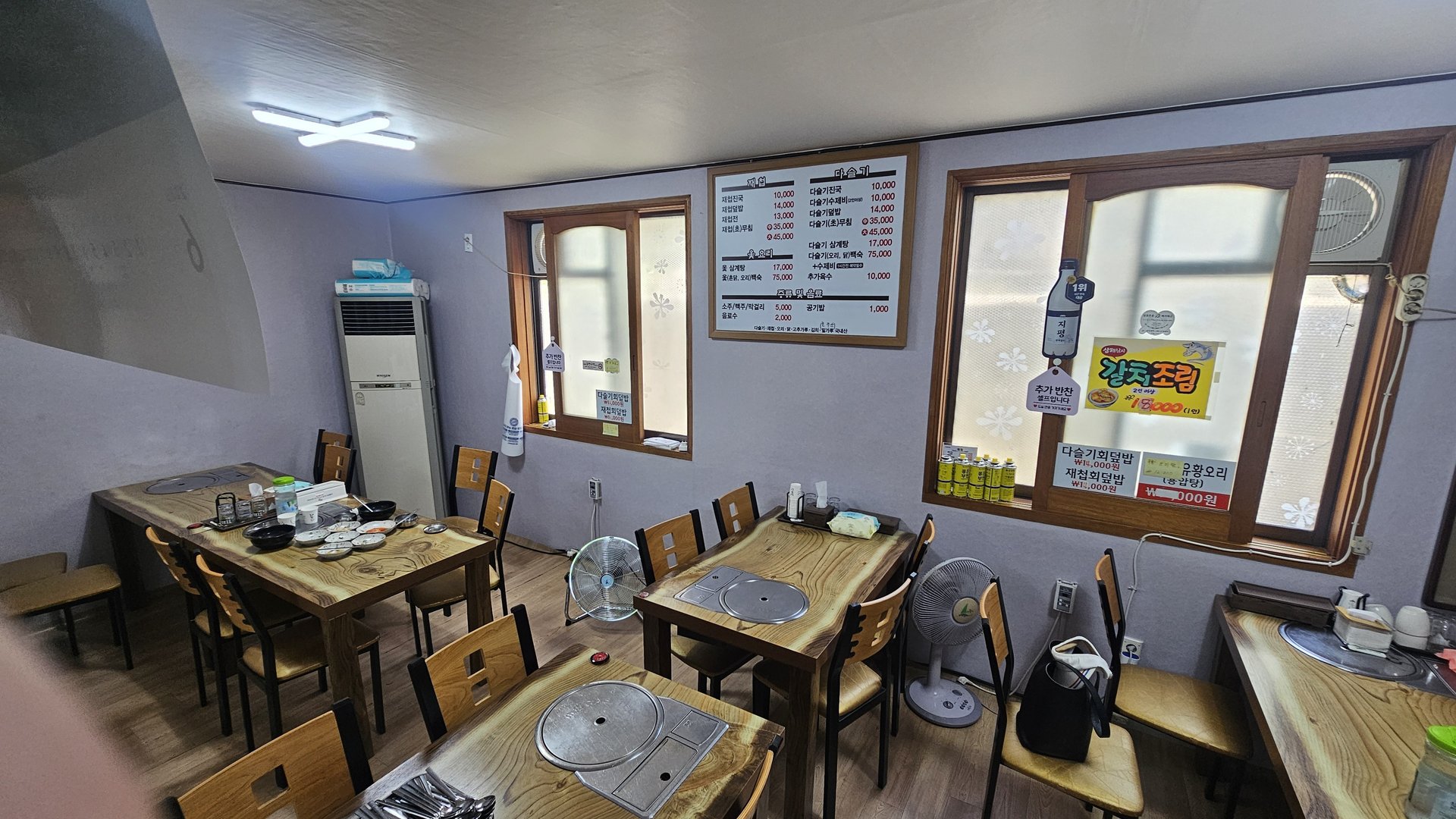 Spacious main dining hall at Gareung Sikdang Hadong with wooden tables, chairs, fans, and large windows