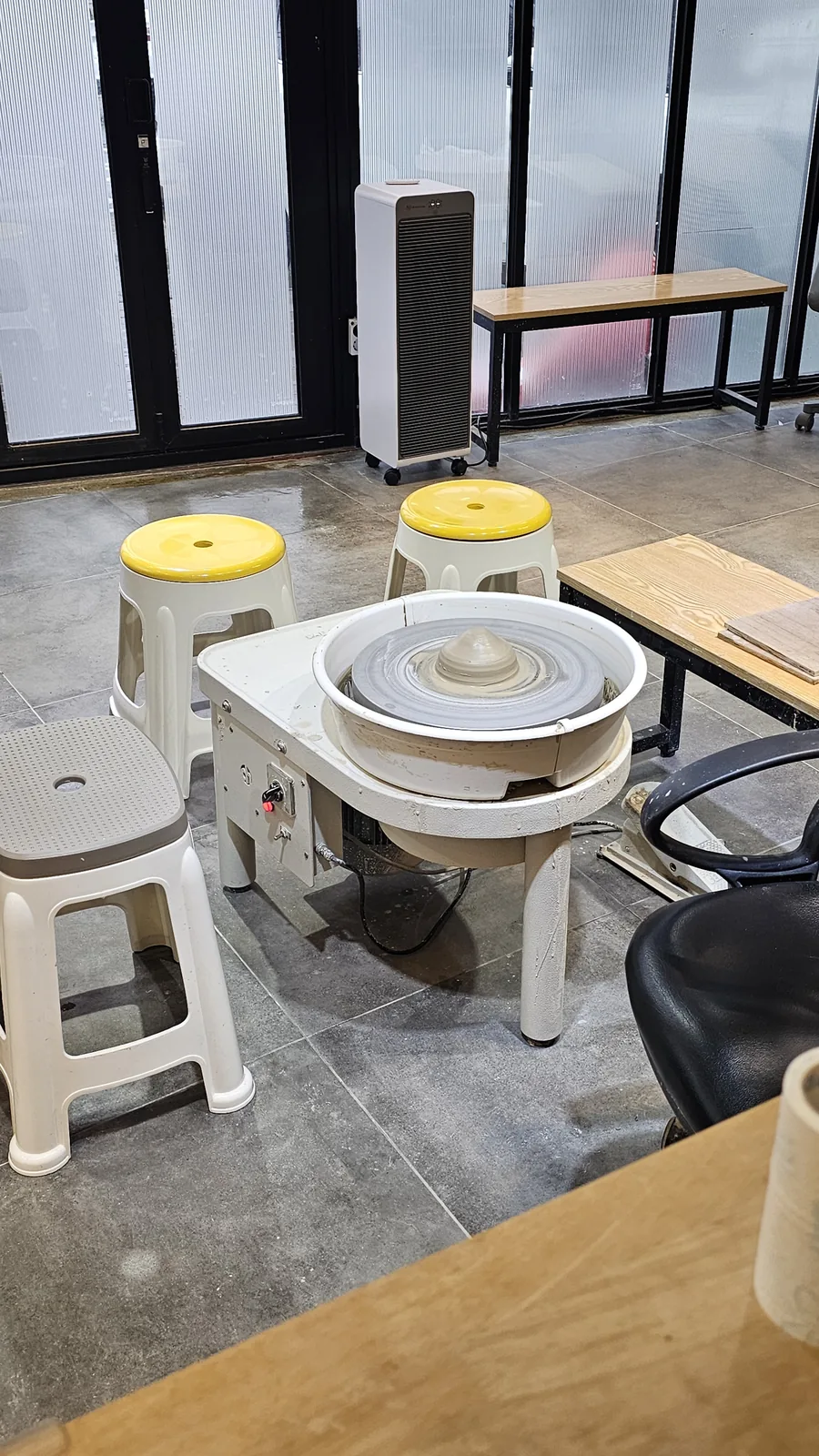 Pottery wheel experience area at Udoye Gongbang with yellow stool seats and electric wheels