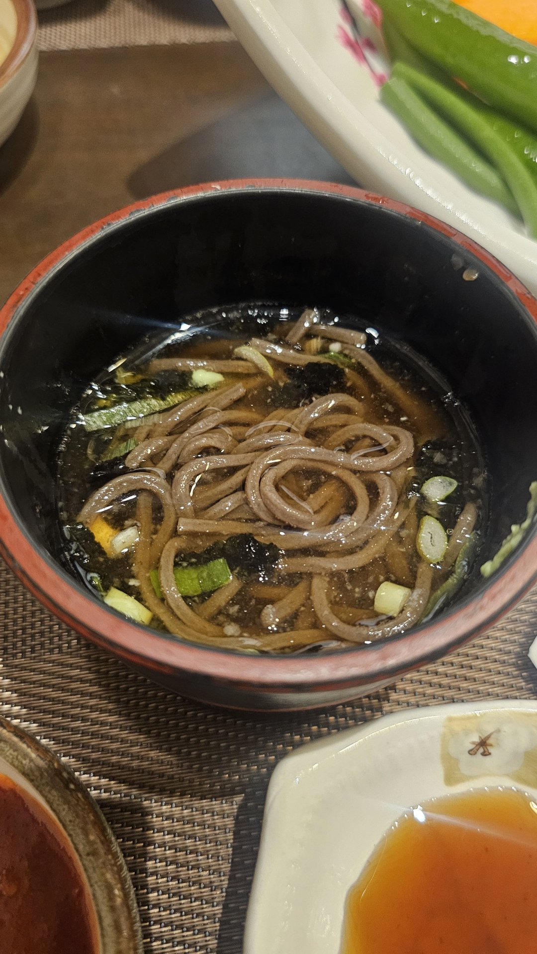 Hot soba noodles in black lacquer bowl topped with scallions and seaweed at Ginza Yeouido