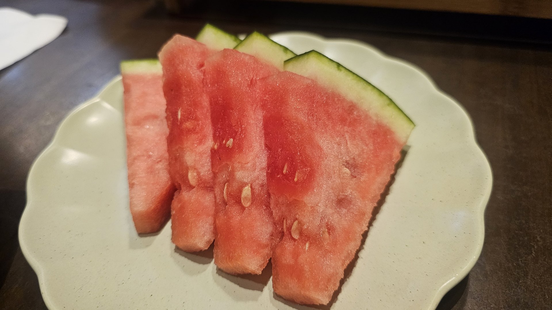 Dessert watermelon sliced into four triangular pieces on white plate at Ginza Yeouido