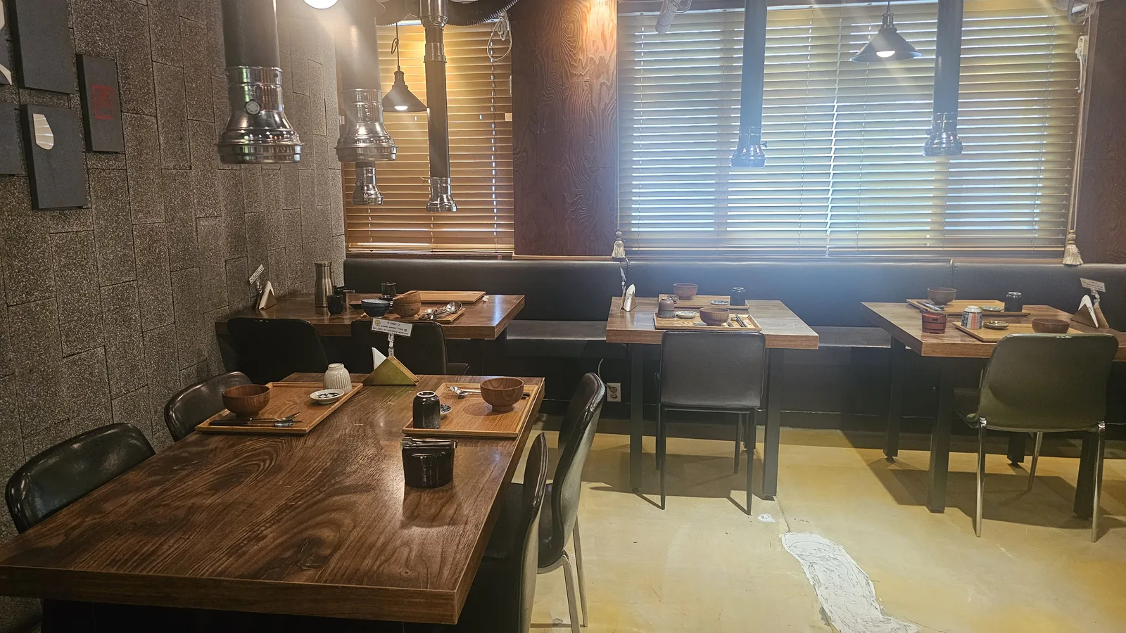 Interior of GU.I Yeouido restaurant with wooden tables and individual charcoal grill setups