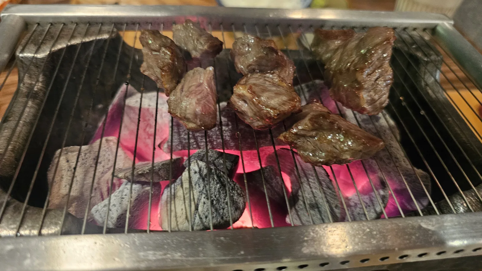 Beef grilling on individual charcoal grill at GU.I Yeouido