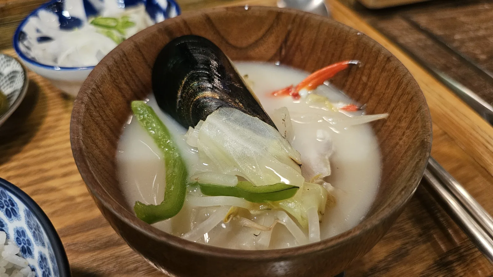 Nagasaki-style soup in wooden bowl with mussels, green and red chili, white broth at GU.I Yeouido