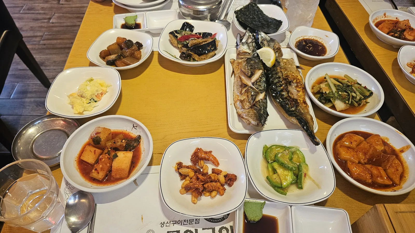 Full Korean grilled fish set at Guigui Yeouido with two whole mackerel and over ten side dishes covering the table