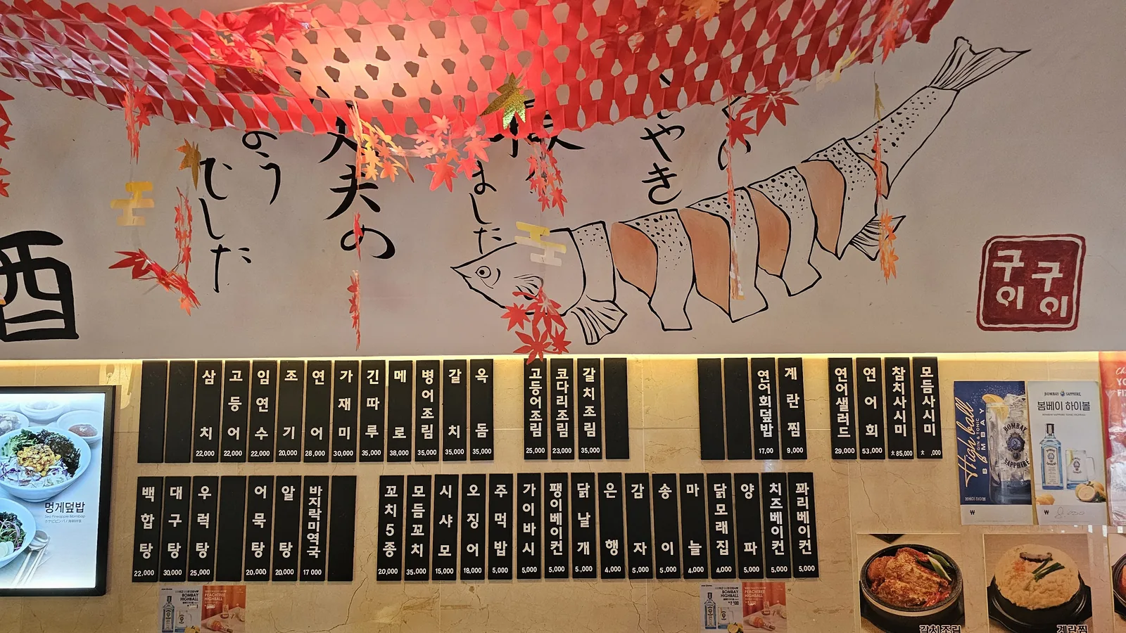 Chalk menu board on ceiling at Guigui Yeouido with autumn leaf and fish motif decorations