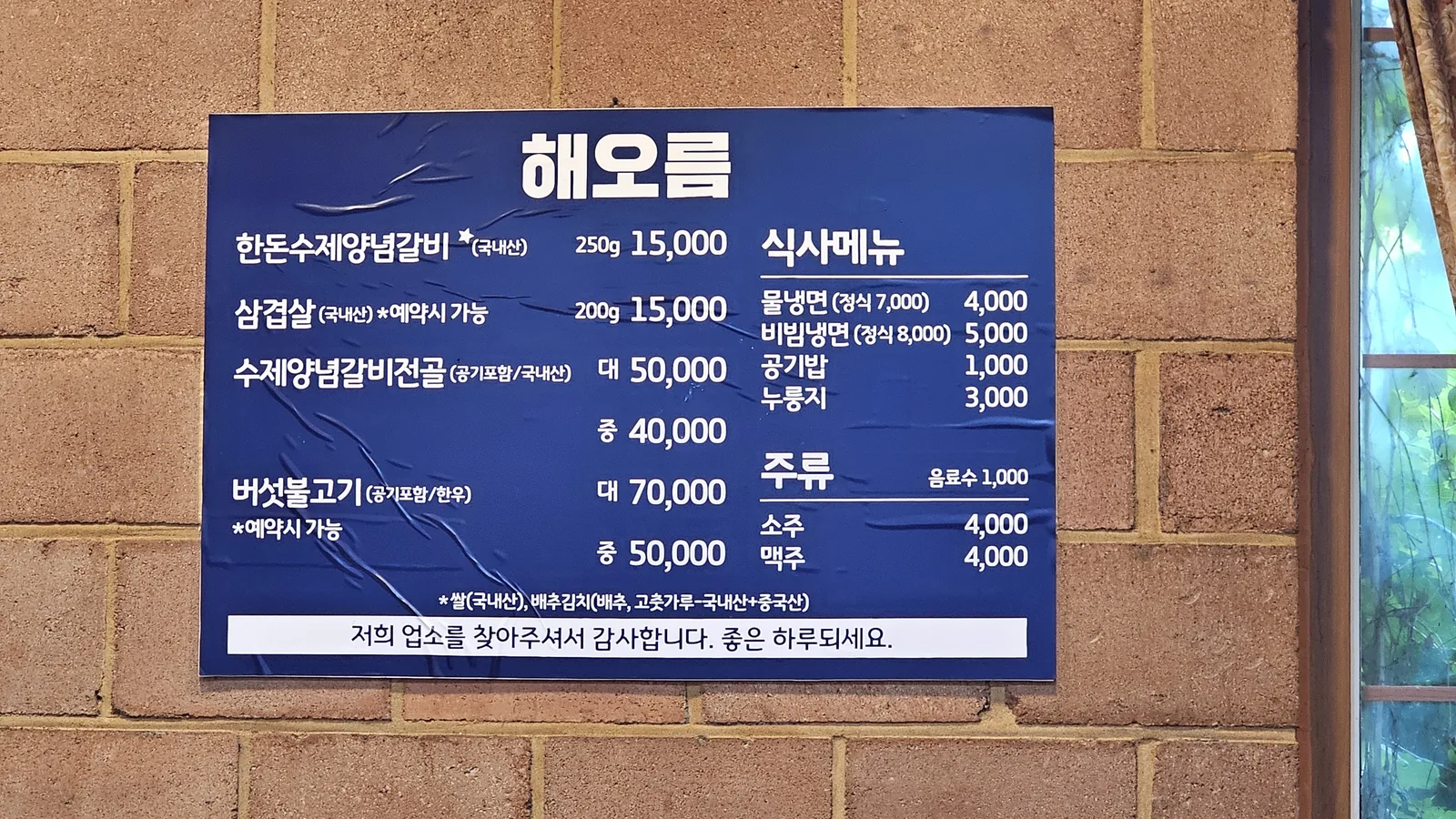 Full menu board on exterior wall of Haeoeum showing food and drink prices including galbi and noodles