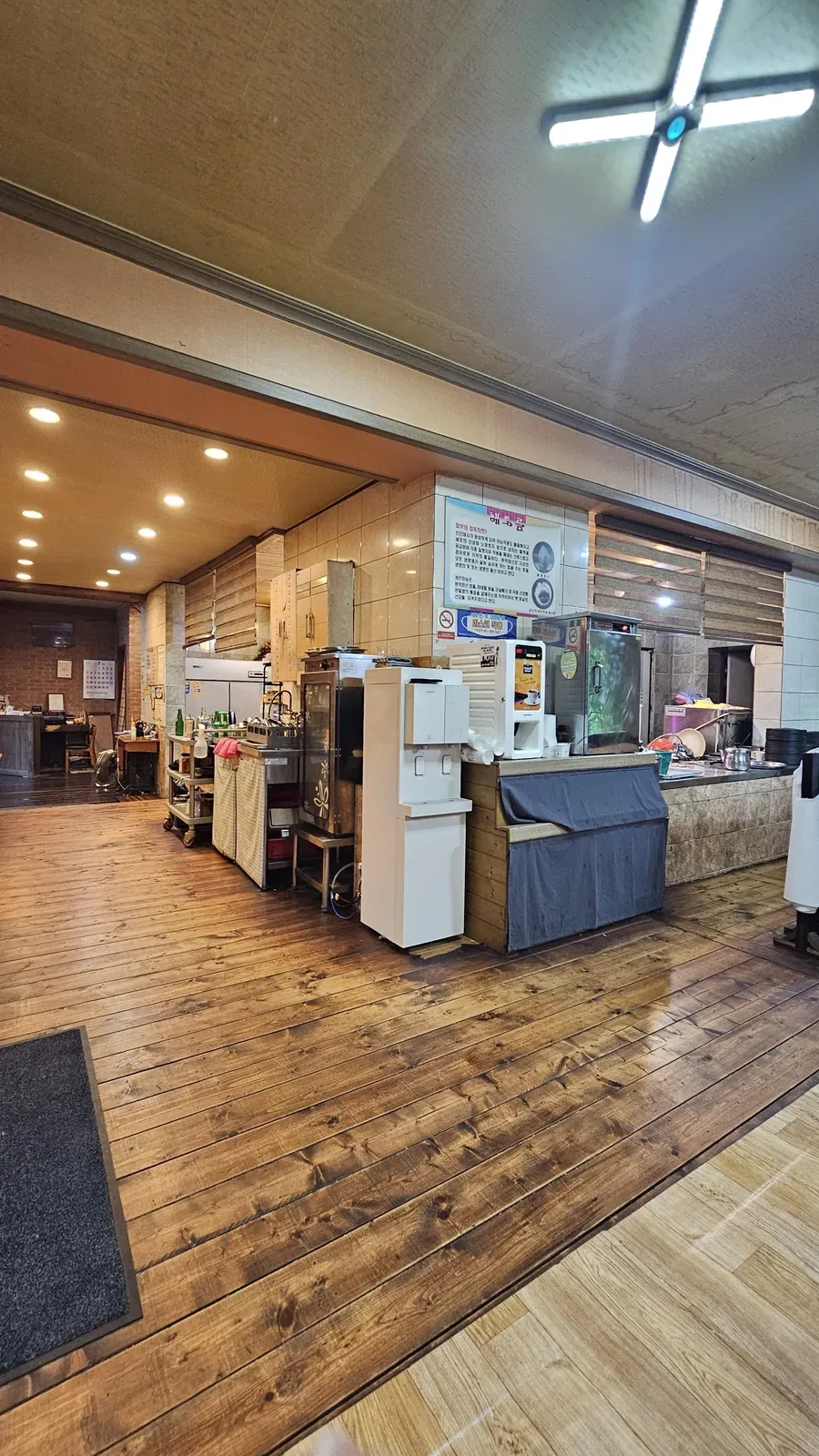 Wide view of Haeoeum dining hall with wooden floors and kitchen equipment visible
