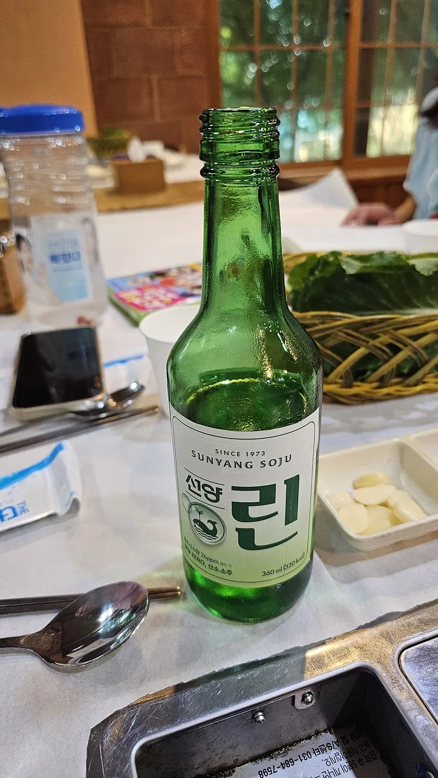 Sunyang soju Rin bottle close-up on table with banchan dishes in background at Haeoeum