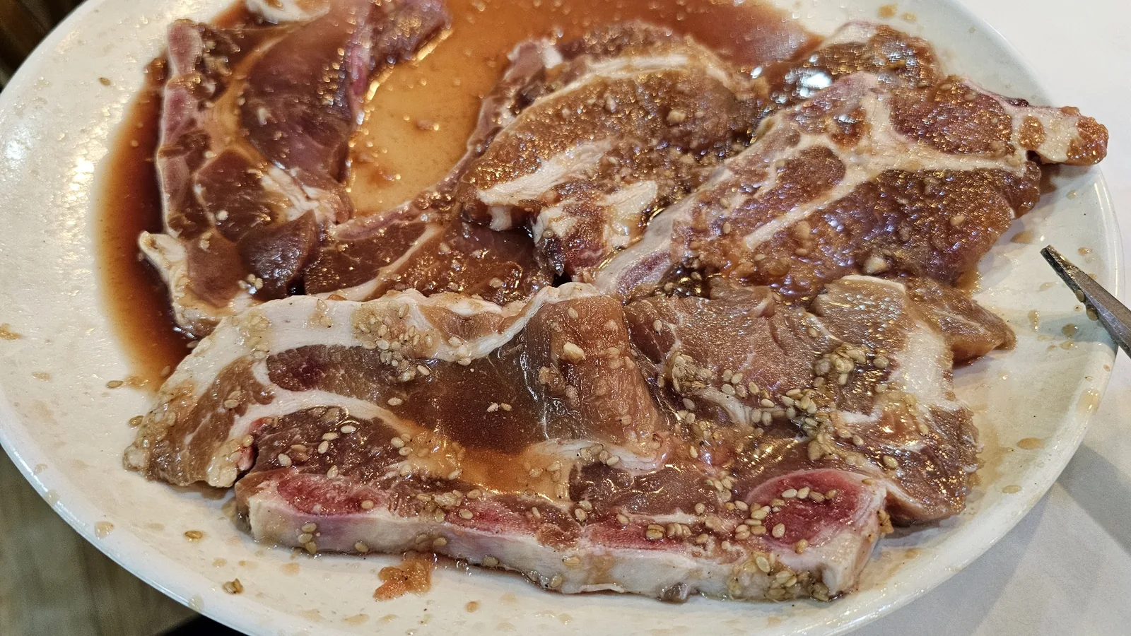 Raw marinated yangnyeom dwaeji galbi on a plate before grilling at Haeoeum Cheongyang