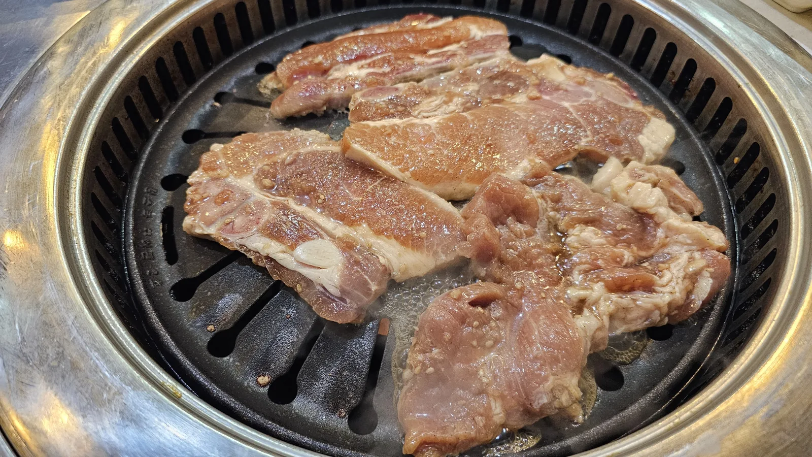 Yangnyeom dwaeji galbi placed on tabletop grill at the beginning of cooking at Haeoeum