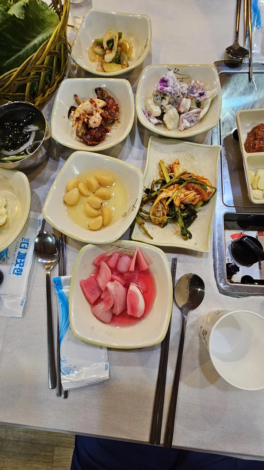 Overhead view of banchan dishes at Haeoeum including whole garlic, pickled onion, pa-kimchi, and stir-fried dried anchovies