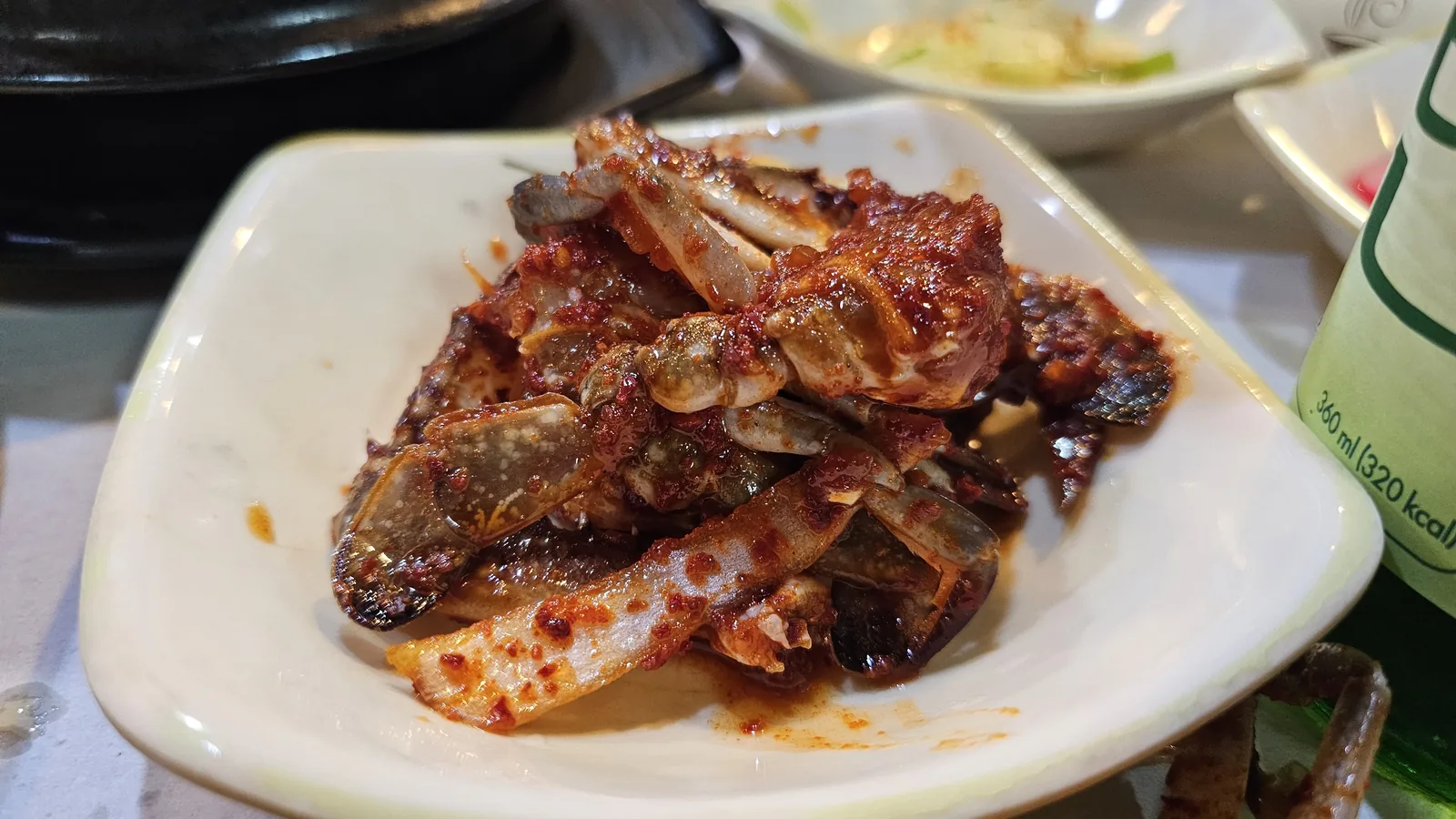 Spicy marinated raw crab banchan in bright red sauce at Haeoeum Cheongyang