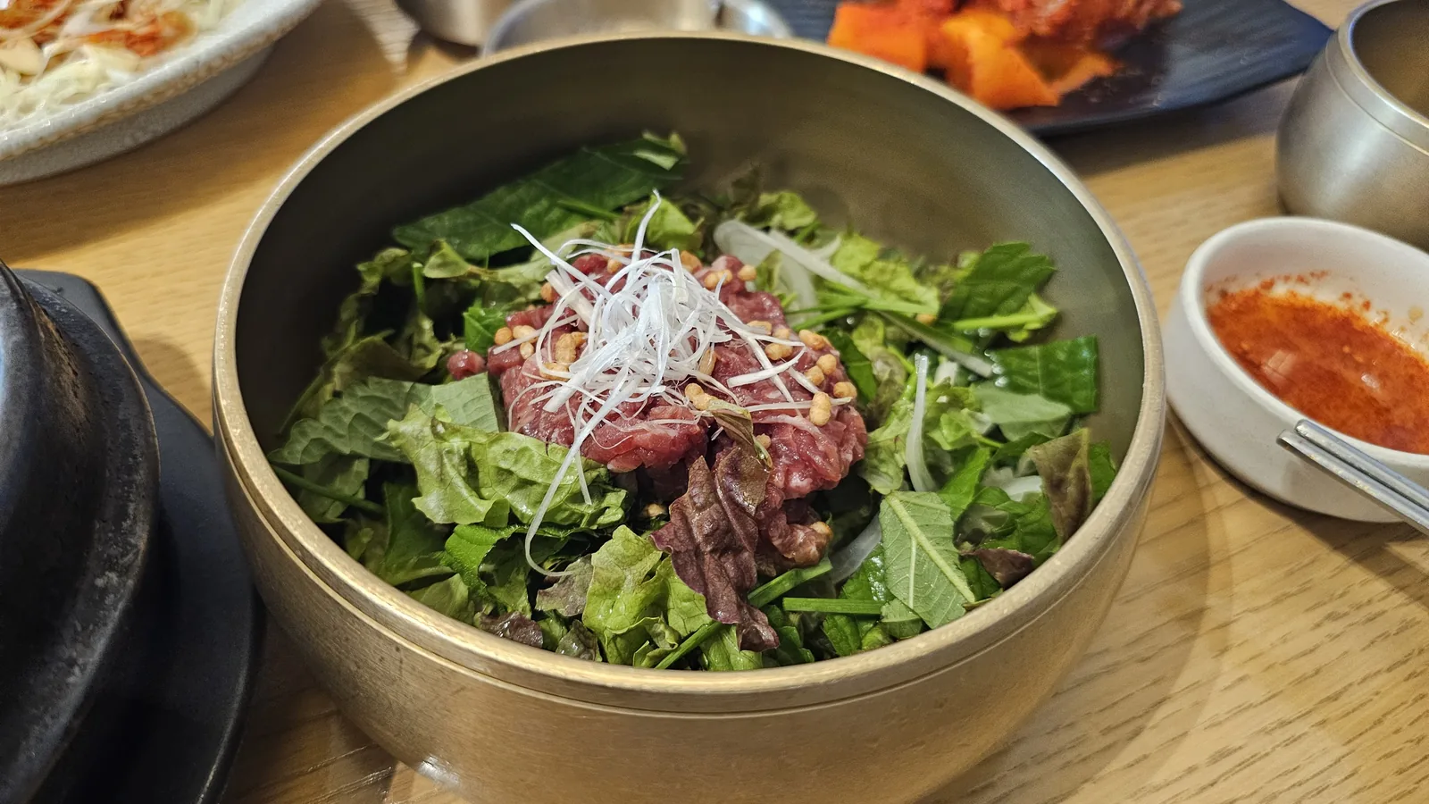 Raw hanwoo beef and vegetable ssam bowl served alongside sea bream stone pot rice before mixing at Hanam-dong