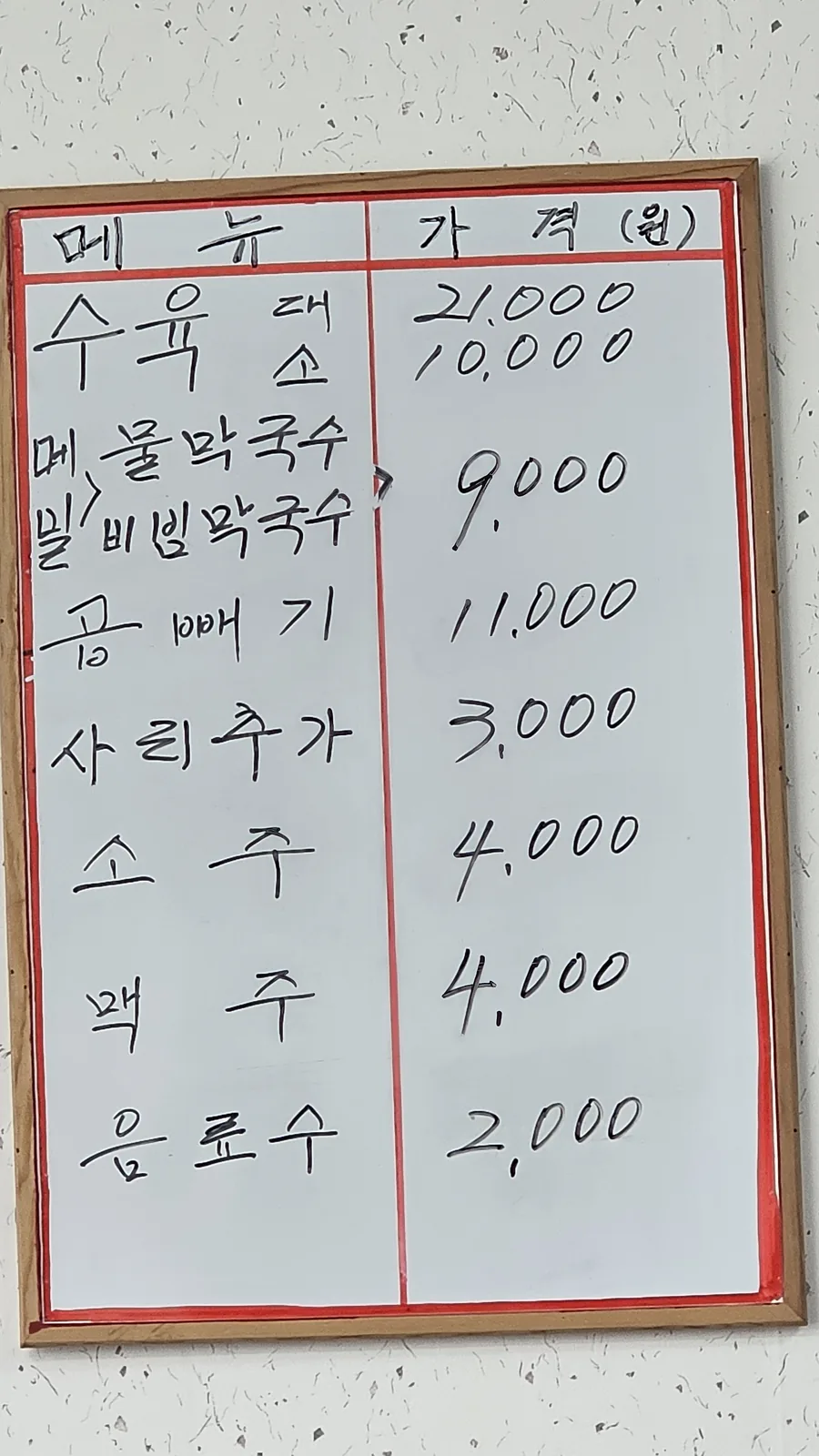 Handwritten menu board at Jangsu Makguksu showing prices for subyuk, buckwheat makguksu, and bibim makguksu