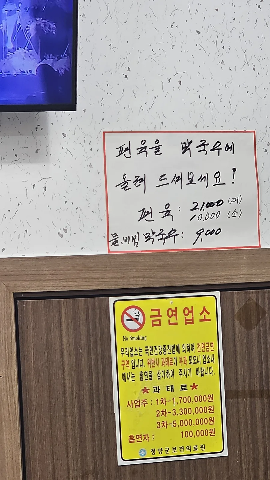 Restaurant notice at Jangsu Makguksu instructing diners to place subyuk slices on top of makguksu, with pricing