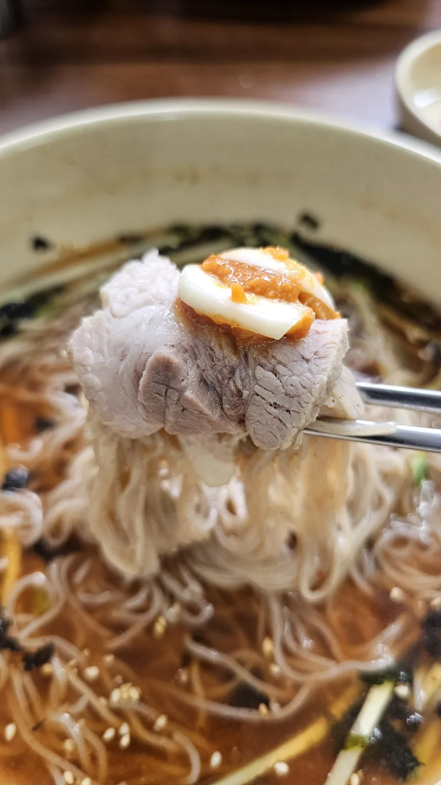 Close-up of a subyuk slice placed on top of buckwheat makguksu noodles at Jangsu Makguksu Cheongyang
