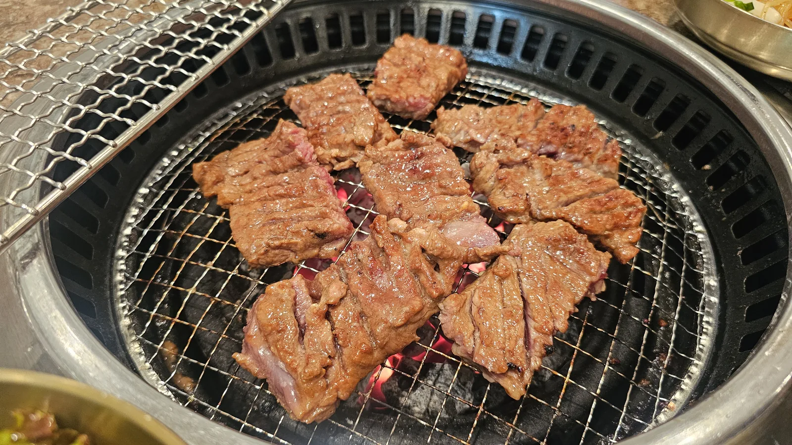 Cut galbi pieces almost fully cooked on the charcoal grill at Jogane Galbi Mokdong