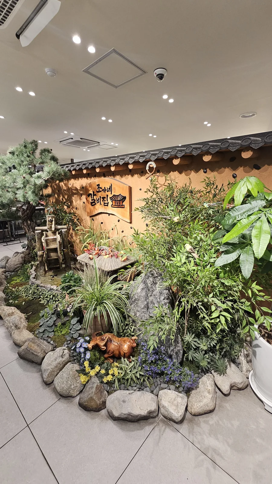 Indoor garden landscaping and Jogane Galbi hanok-concept signage inside the restaurant