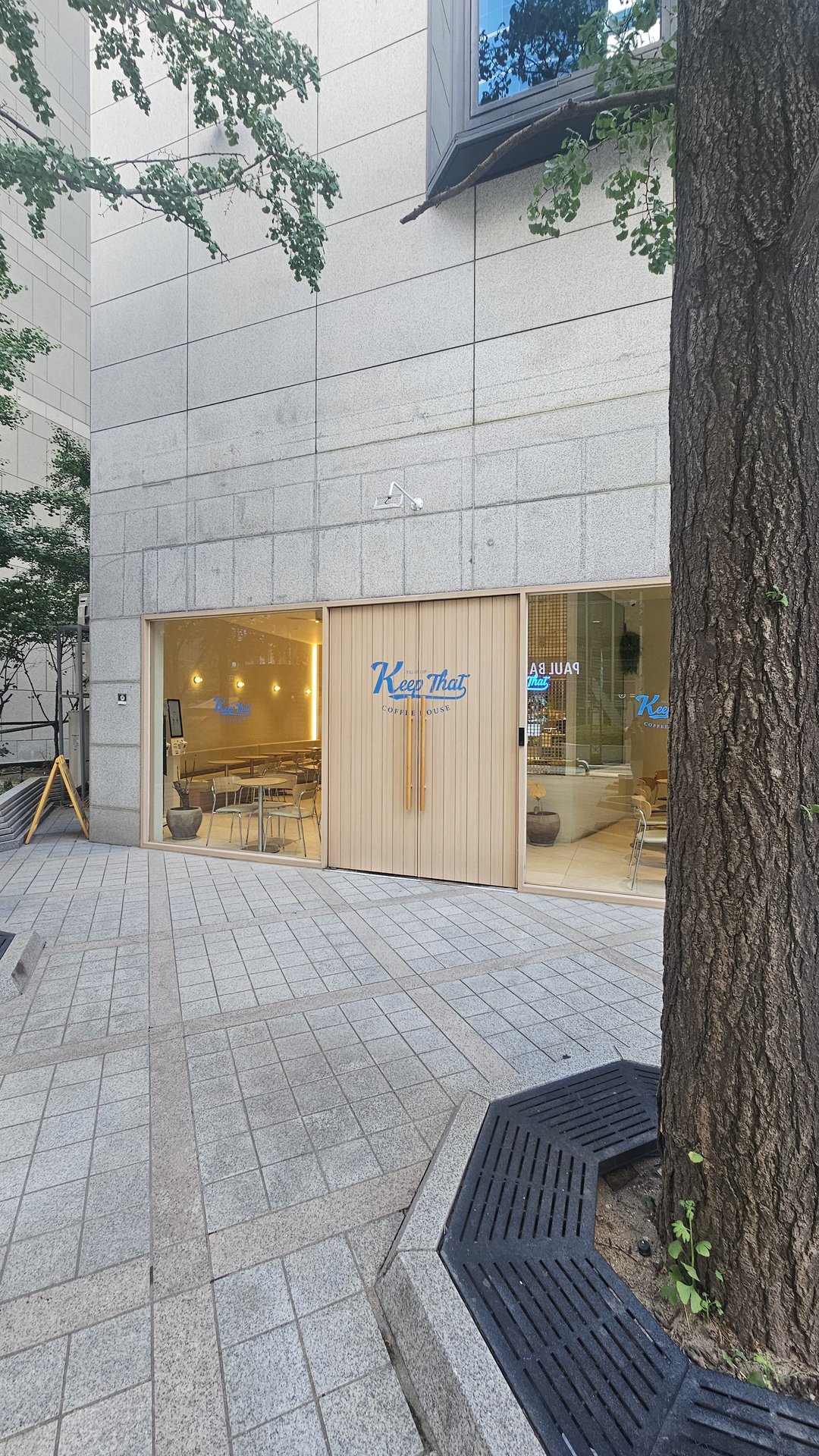 Keep That Coffee House Yeouido exterior with floor-to-ceiling glass facade and street trees