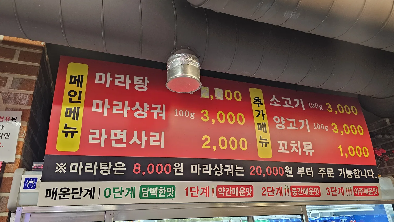 Close-up of malatang menu board showing bowl options and spice levels at Miyeon Yangkkochi