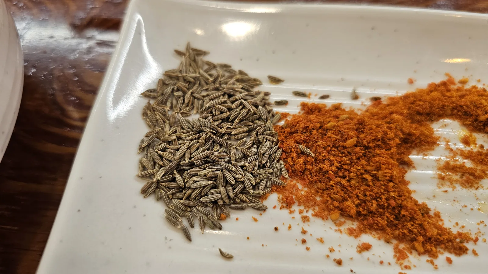 Cumin seeds and red chili powder spice plate for dipping yangkkochi at Miyeon Maratang