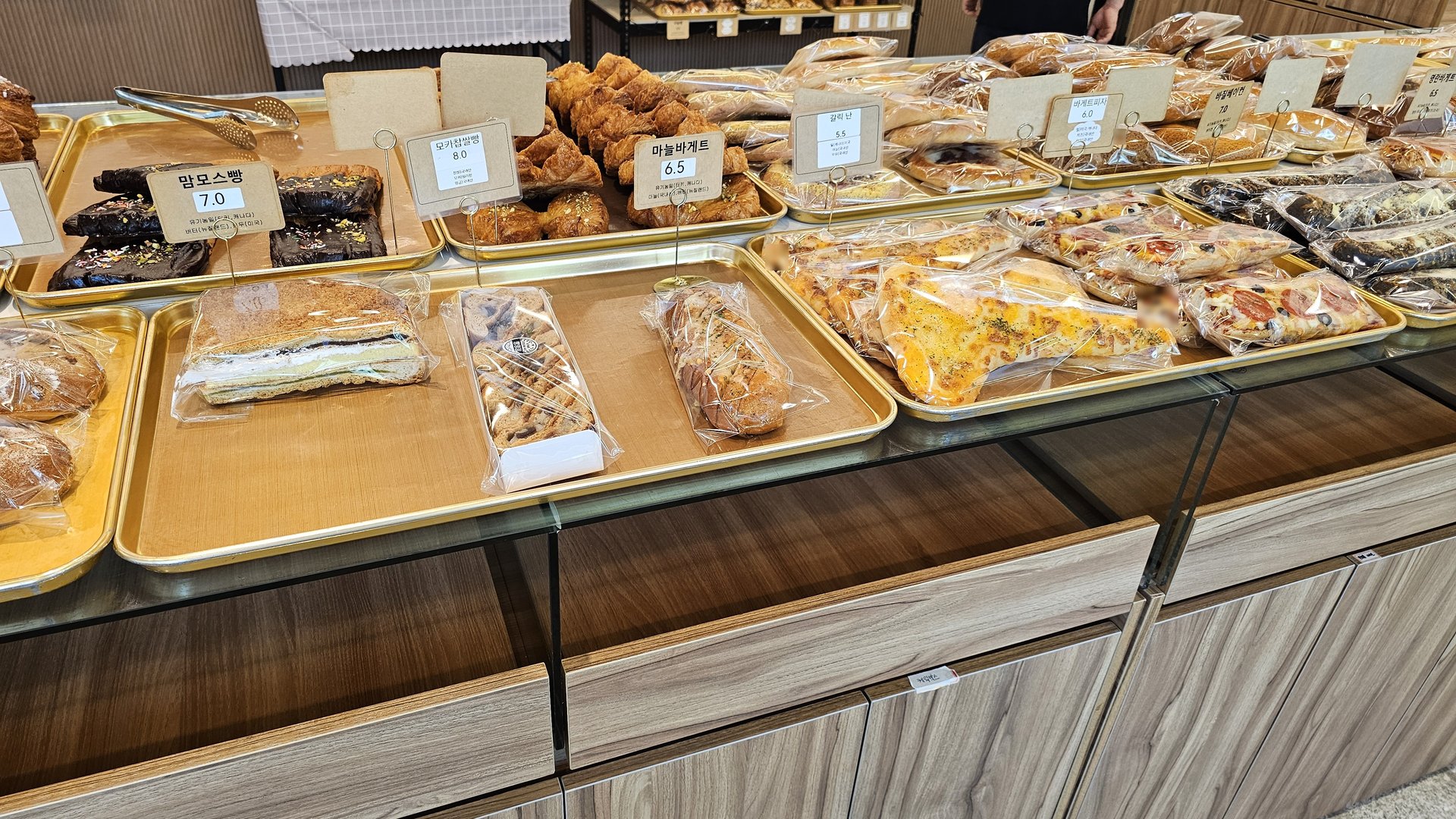 Almond cream bread and garlic baguette trays displayed at Mochang-po Master Baker Cafe