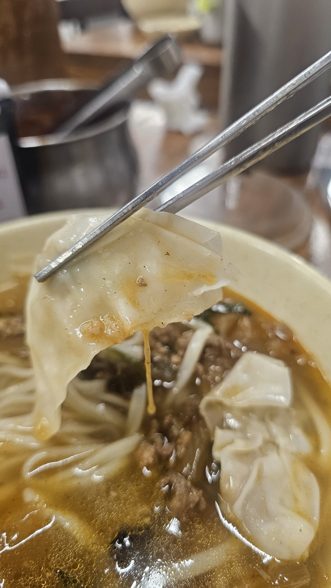 Chopsticks lifting kalguksu knife-cut noodles from bowl at Myeongdong Gyoja