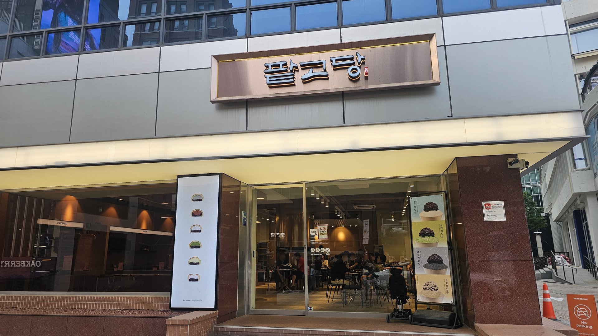 Patgodang Myeongdong storefront exterior with bingsu poster and glass facade showing customers inside