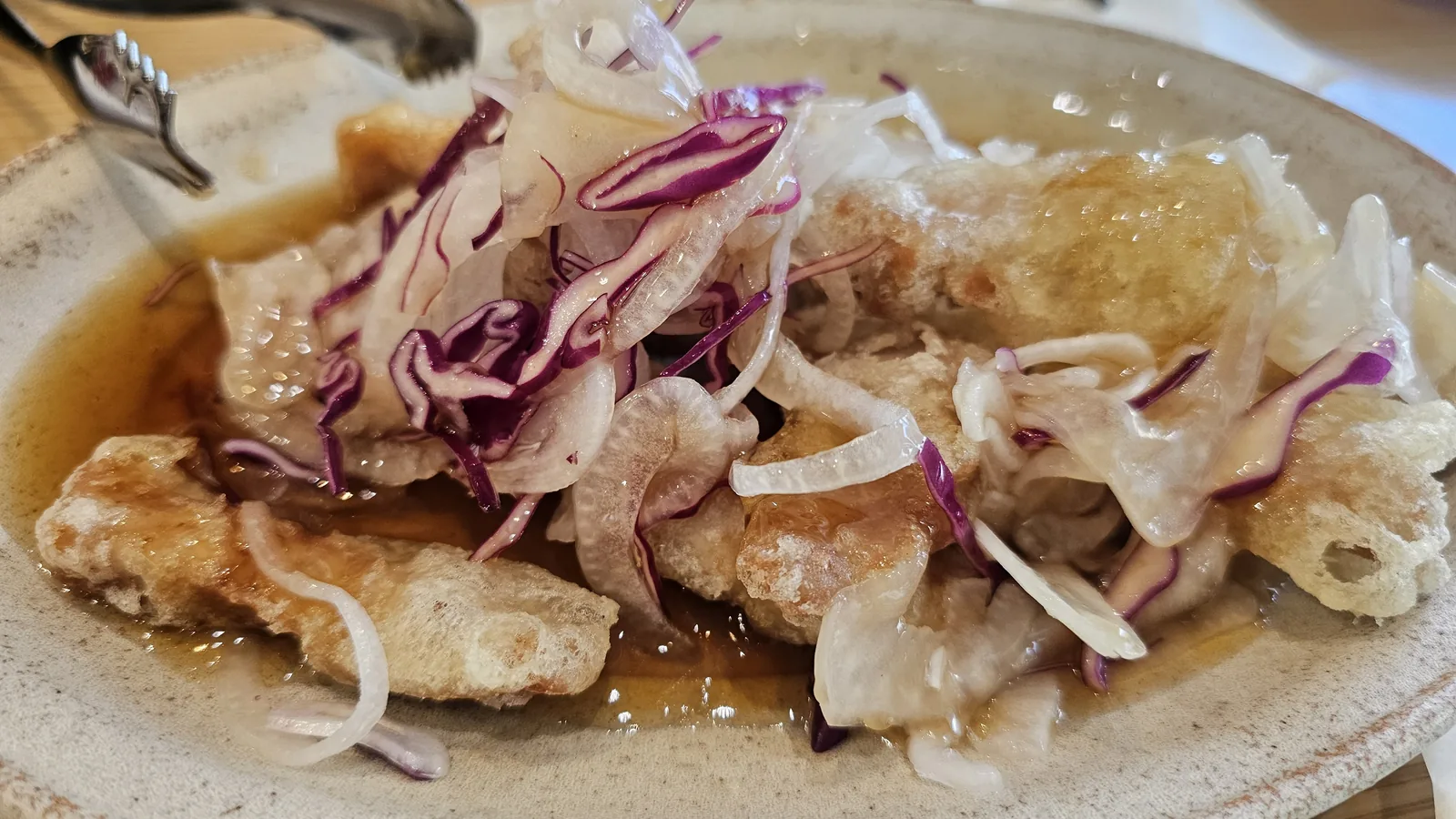 Sacheon Hwaga-style tangsunyuk — crispy fried pork topped with shredded onion and red cabbage in Sichuan sauce