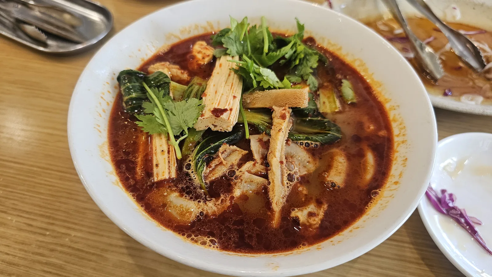 Mala broth noodles with yuba tofu skin, bok choy and cilantro in dark red Sichuan peppercorn broth at Sacheon Hwaga