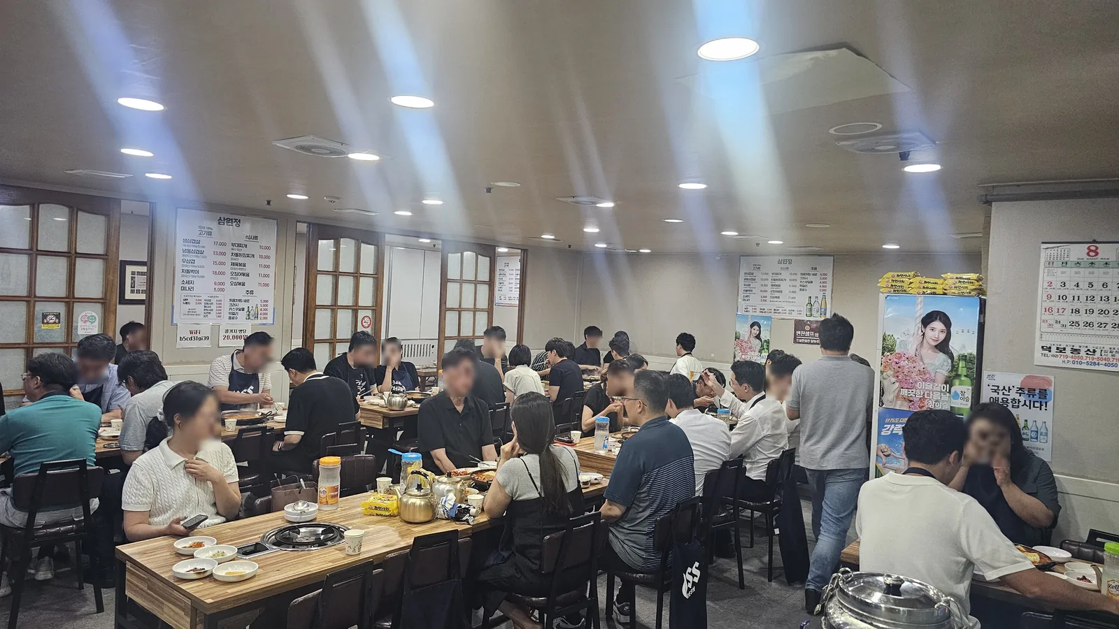 壁に大きな韓国語メニューボードが掲げられたサムォンジョン汝矣島の混み合うランチタイムの様子