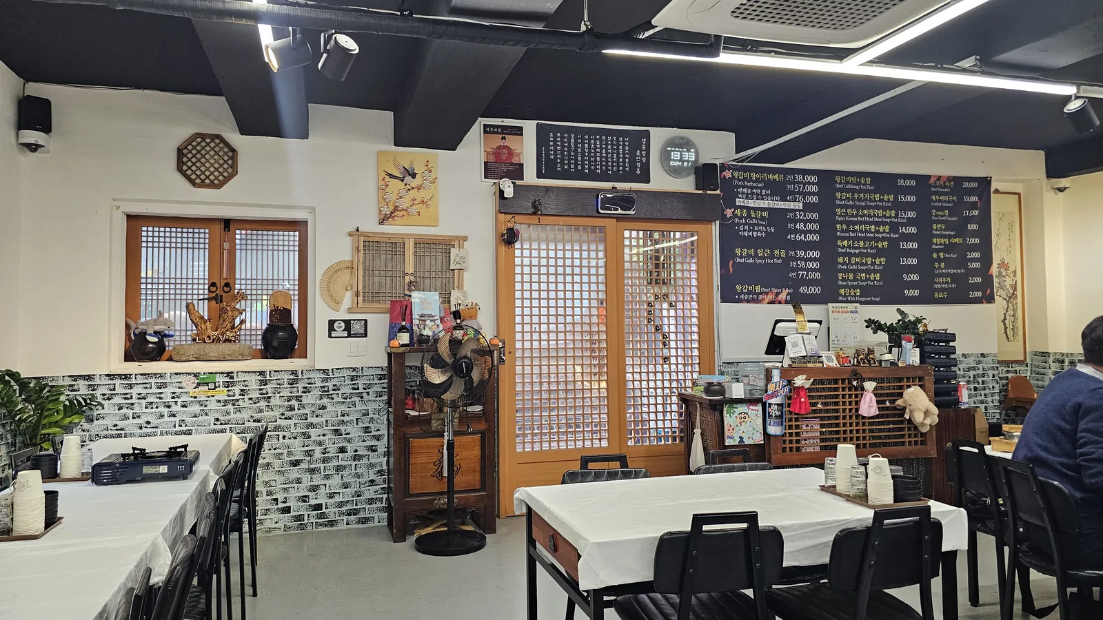 Interior of Sejong Daewang Hangari restaurant with traditional Korean lattice window frames and white-clothed dining tables