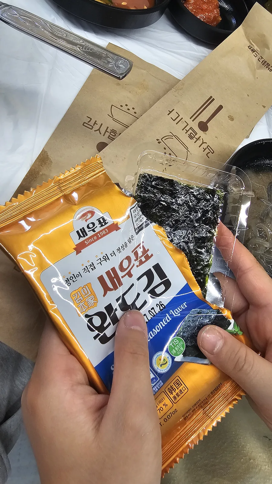 Complimentary dried seaweed snack from Wando being unwrapped at the table at Sejong Daewang Jeonju
