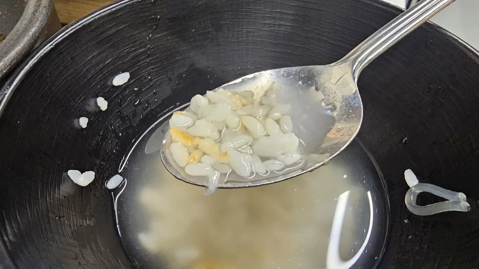 Close-up of nurungji rice crust with a spoon scooping sungnyung tea at Sejong Daewang Jeonju