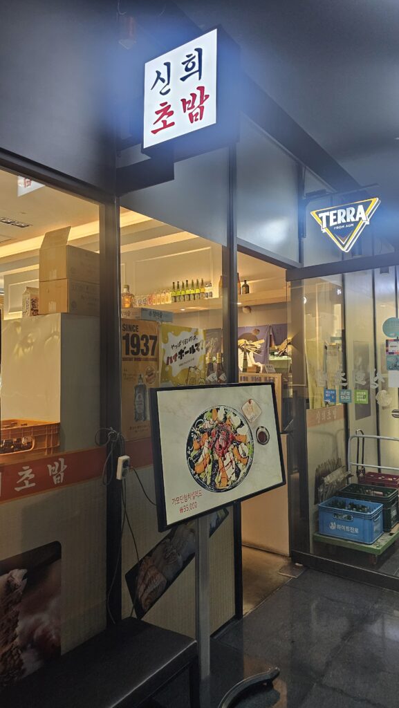 Shinhee Sushi restaurant entrance in Yeouido with signage glass doors and menu display board