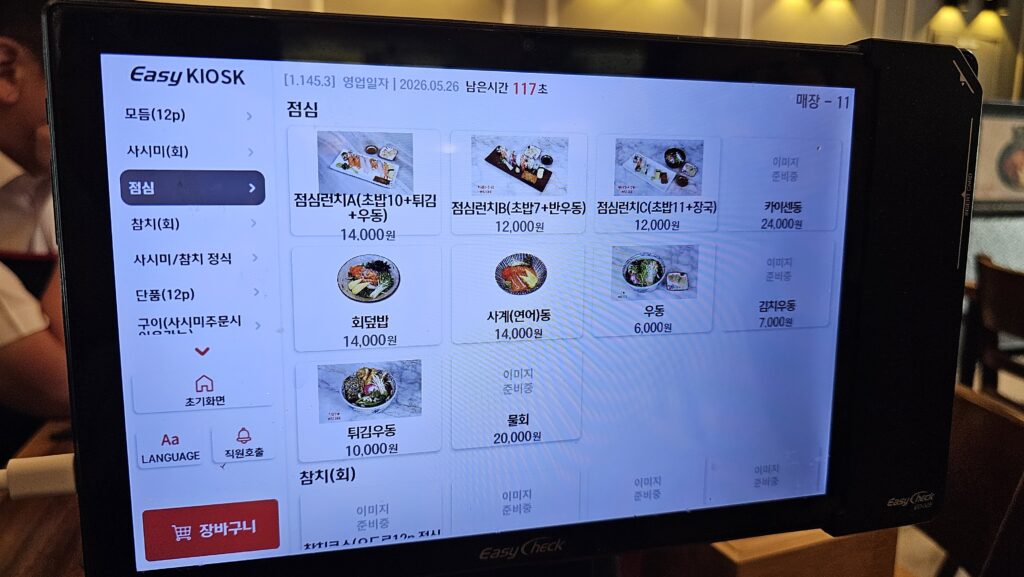 Kiosk touch screen lunch menu at Shinhee Sushi showing Lunch Set A 14000 KRW with sushi tempura udon