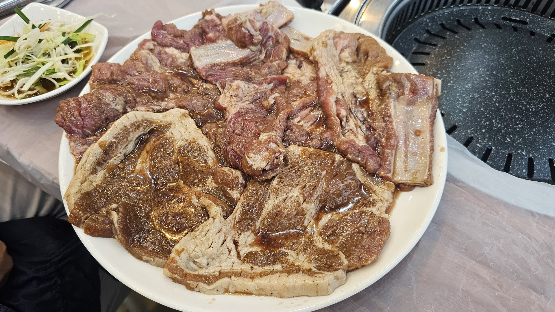 Raw marinated pork ribs (yang-nyeom galbi) on a plate before grilling at Songnim Cheongyang