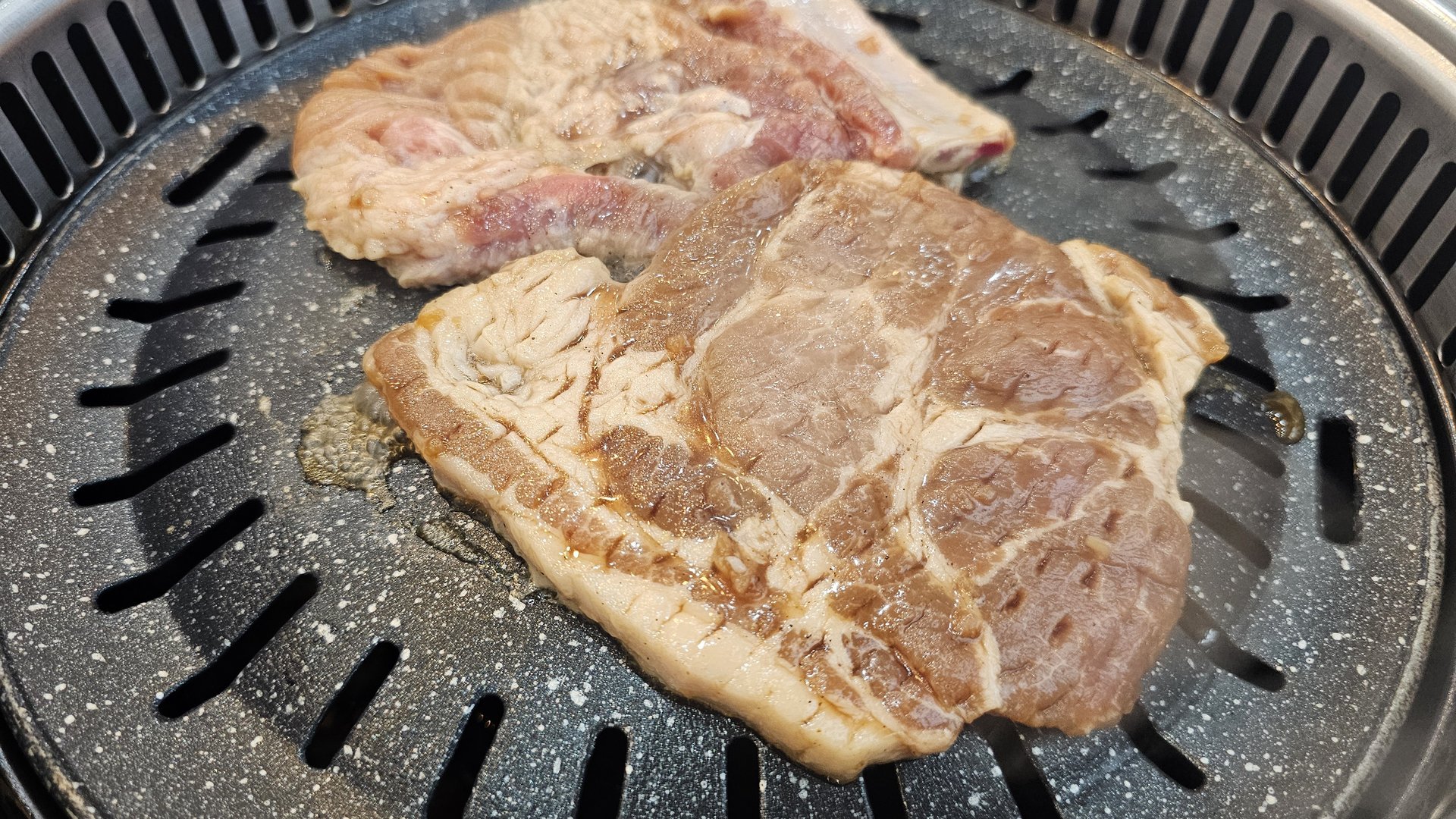 Marinated pork ribs at the start of grilling on the tabletop BBQ at Songnim Cheongyang