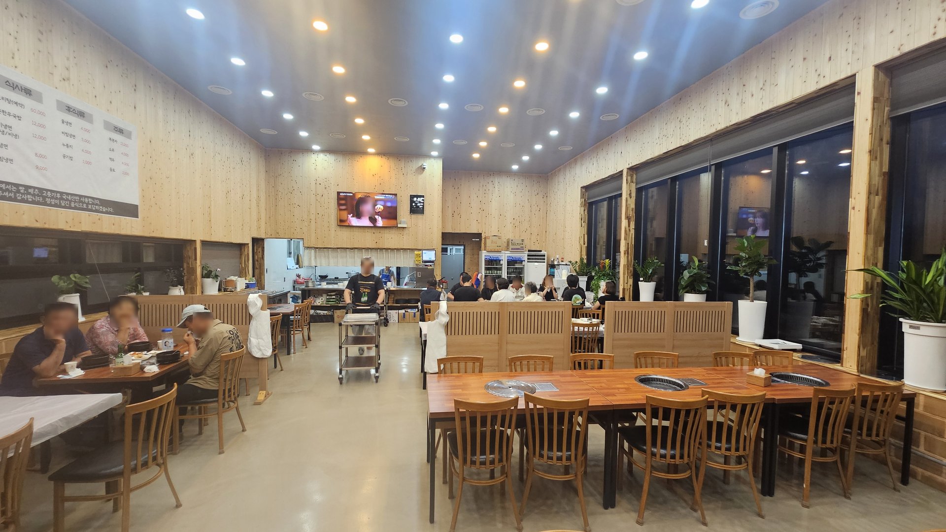 Evening interior of Songnim Cheongyang dining hall with lights on and most tables occupied